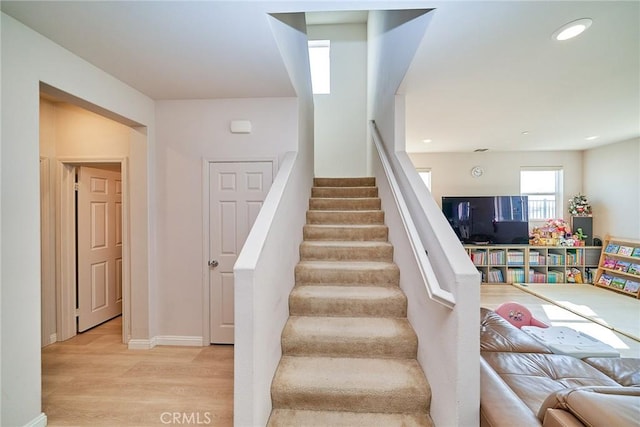 stairway with recessed lighting, baseboards, and wood finished floors