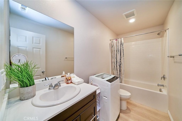 bathroom with vanity, wood finished floors, visible vents, shower / bath combo, and toilet