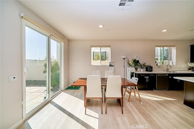 dining area featuring visible vents, a healthy amount of sunlight, and light wood-style flooring