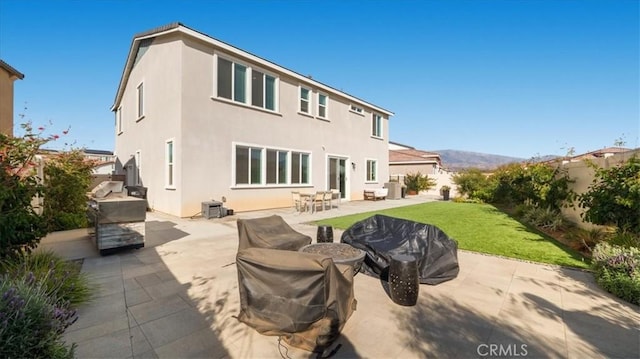 rear view of property with a patio area and stucco siding