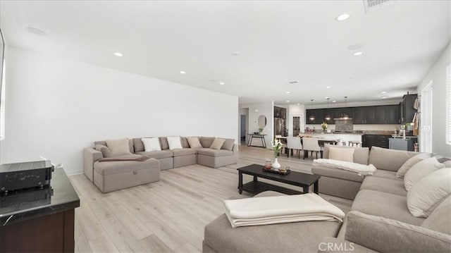 living room with light wood finished floors and recessed lighting