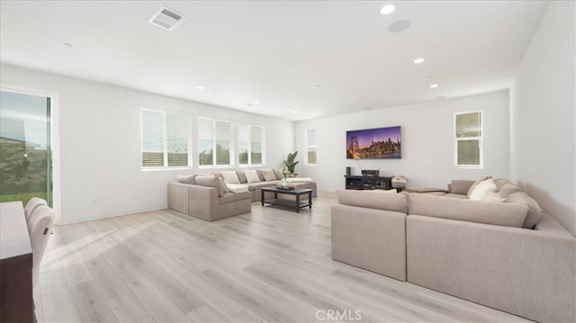 living room with light wood-type flooring and recessed lighting