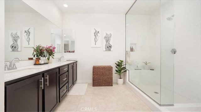 bathroom featuring a tile shower and double vanity