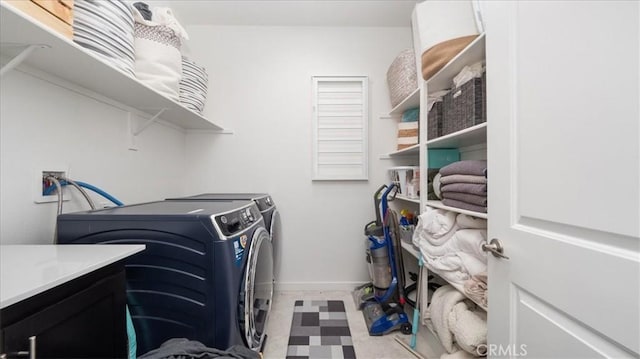 laundry area with washing machine and clothes dryer, tile patterned floors, and baseboards