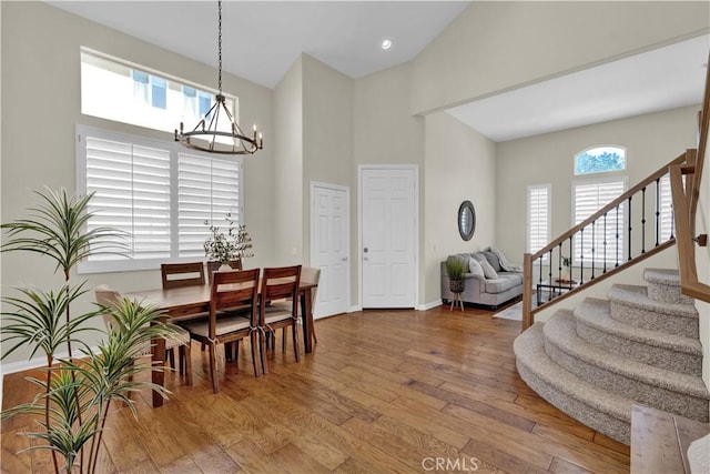 11 Spring View Way, Rancho Santa Margarita, CA 92688 - dining area featuring a chandelier, stairway, hardwood / wood-style floors, a towering ceiling, and baseboards