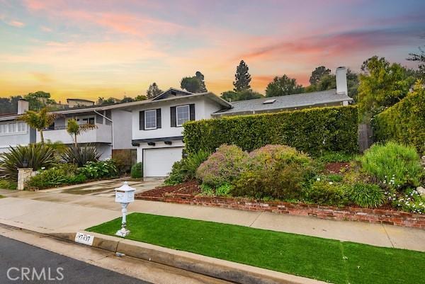 view of front of home featuring stucco siding, a front lawn, concrete driveway, and a garage