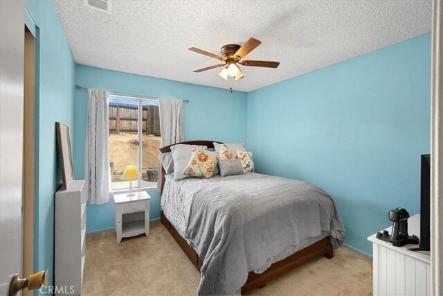 bedroom with baseboards, a textured ceiling, a ceiling fan, and carpet