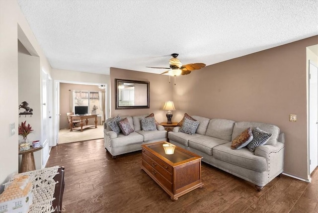 living room with dark wood finished floors, a textured ceiling, and ceiling fan