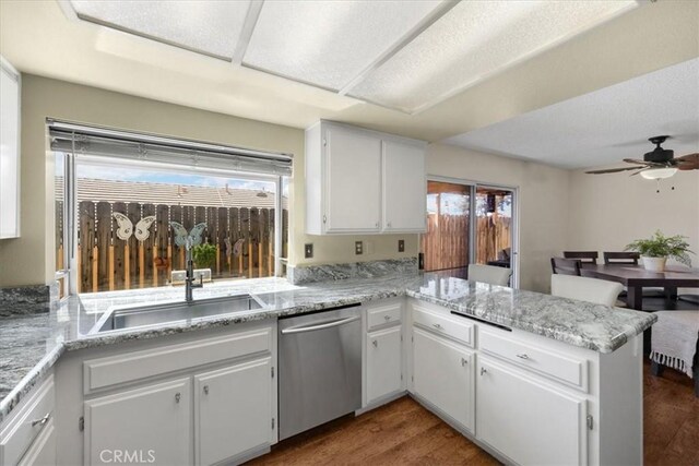 kitchen with dark wood-style floors, a ceiling fan, a peninsula, a sink, and dishwasher