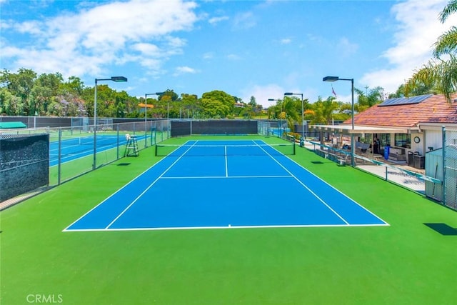 view of tennis court featuring fence