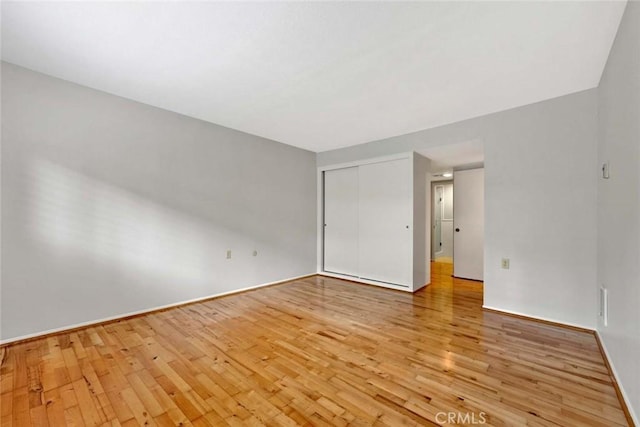 interior space featuring baseboards, a closet, and light wood finished floors