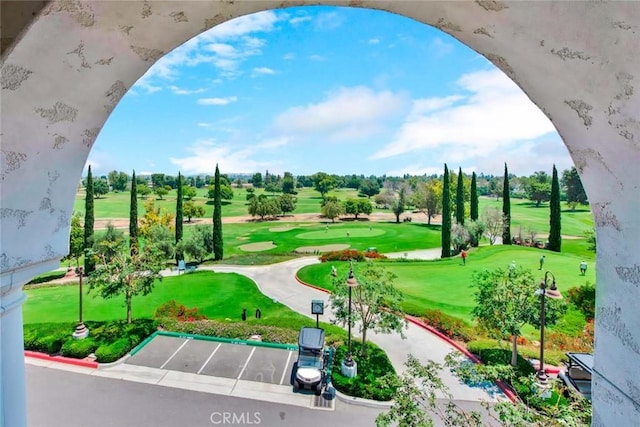 surrounding community featuring a yard, uncovered parking, and view of golf course