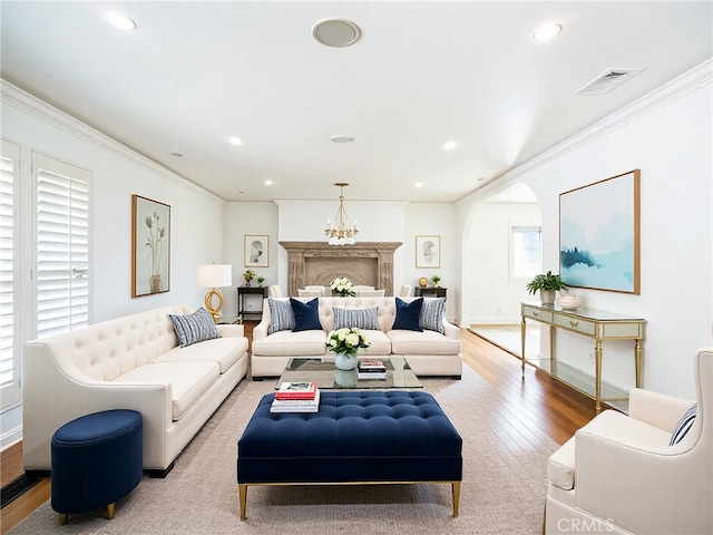 living room with crown molding, recessed lighting, wood finished floors, and visible vents