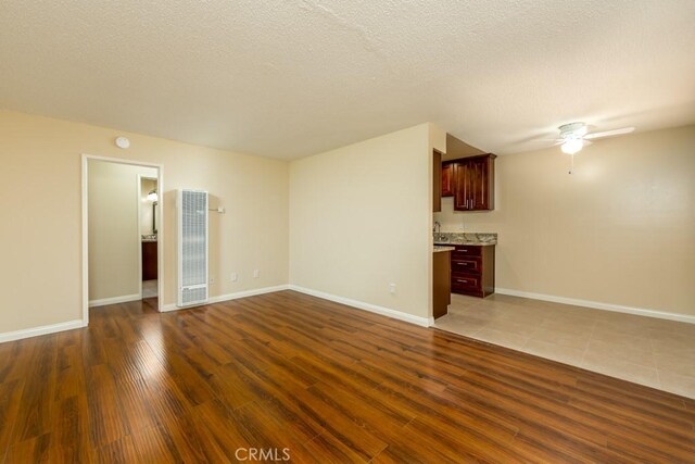 1271 E 7th St, Long Beach, CA 90813 - unfurnished living room with ceiling fan, baseboards, dark wood-type flooring, and a heating unit