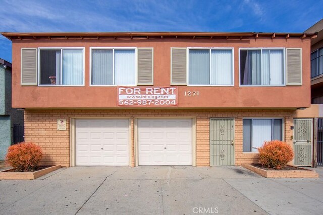 1271 E 7th St, Long Beach, CA 90813 - multi unit property with concrete driveway, stucco siding, brick siding, and a garage