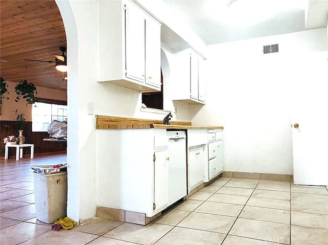 kitchen featuring light tile patterned floors, visible vents, arched walkways, and white cabinets