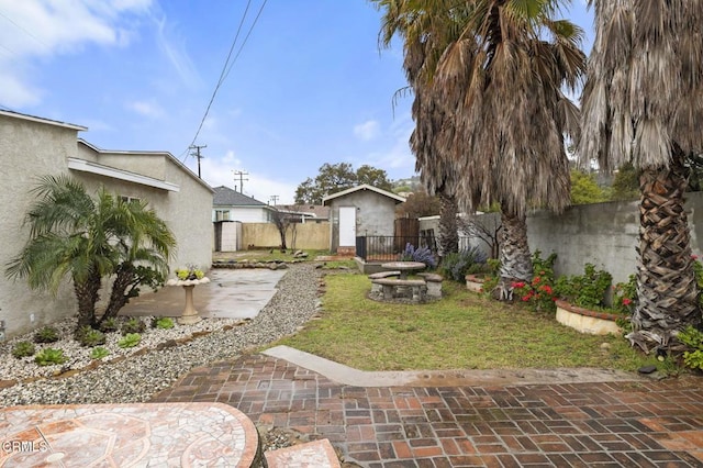 view of yard with an outbuilding, a patio, and a fenced backyard