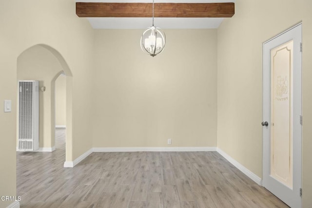 unfurnished room featuring baseboards, beamed ceiling, arched walkways, and an inviting chandelier