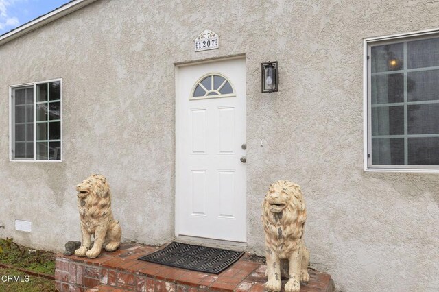 view of exterior entry featuring stucco siding