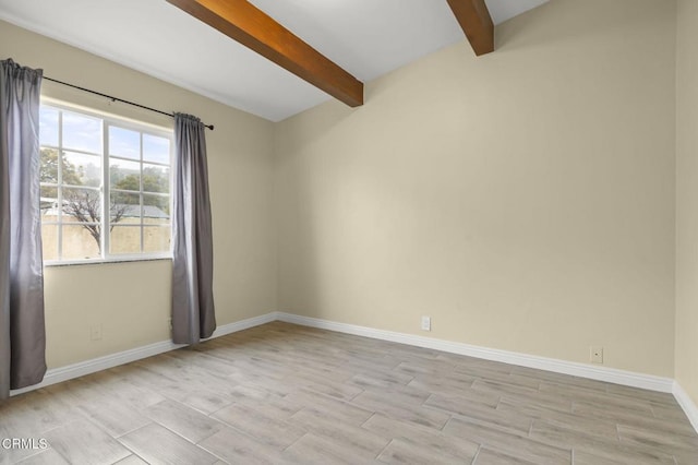empty room with beamed ceiling, wood finish floors, and baseboards