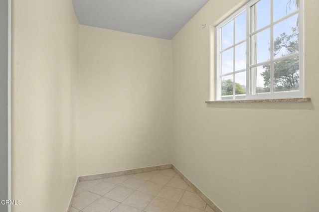 unfurnished room with baseboards and light tile patterned flooring
