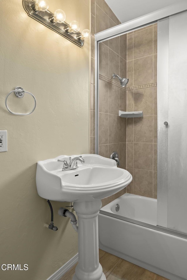 bathroom with enclosed tub / shower combo and wood finished floors