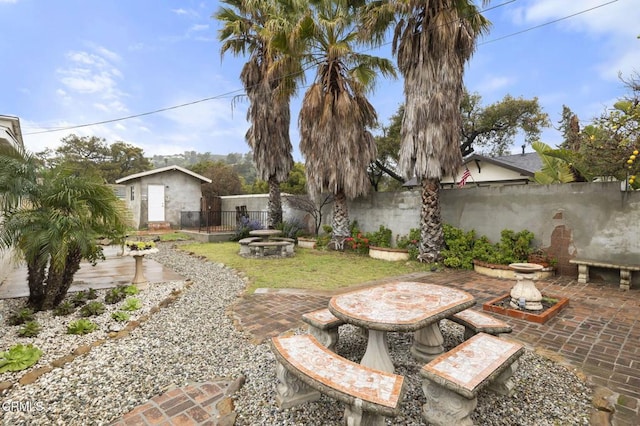 view of yard with a patio, an outdoor structure, and a fenced backyard