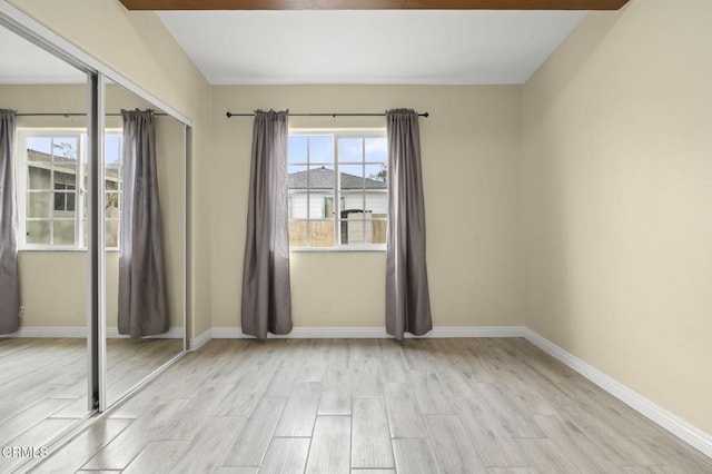 unfurnished room featuring light wood finished floors and baseboards