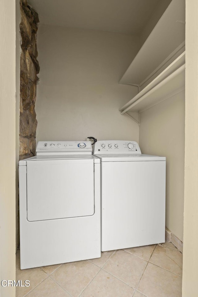 washroom featuring laundry area, light tile patterned floors, and washing machine and dryer