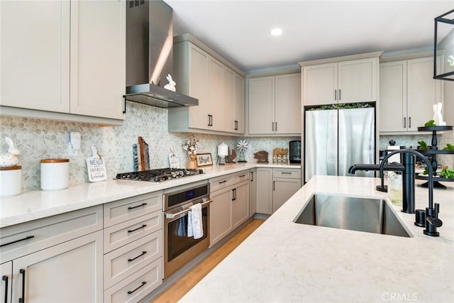 6288 Barb Way, Jurupa Valley, CA 92509 - kitchen featuring stainless steel appliances, wall chimney range hood, a sink, backsplash, and light wood-style floors