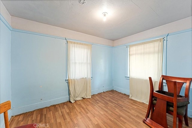 interior space featuring wood finished floors, baseboards, and a textured ceiling