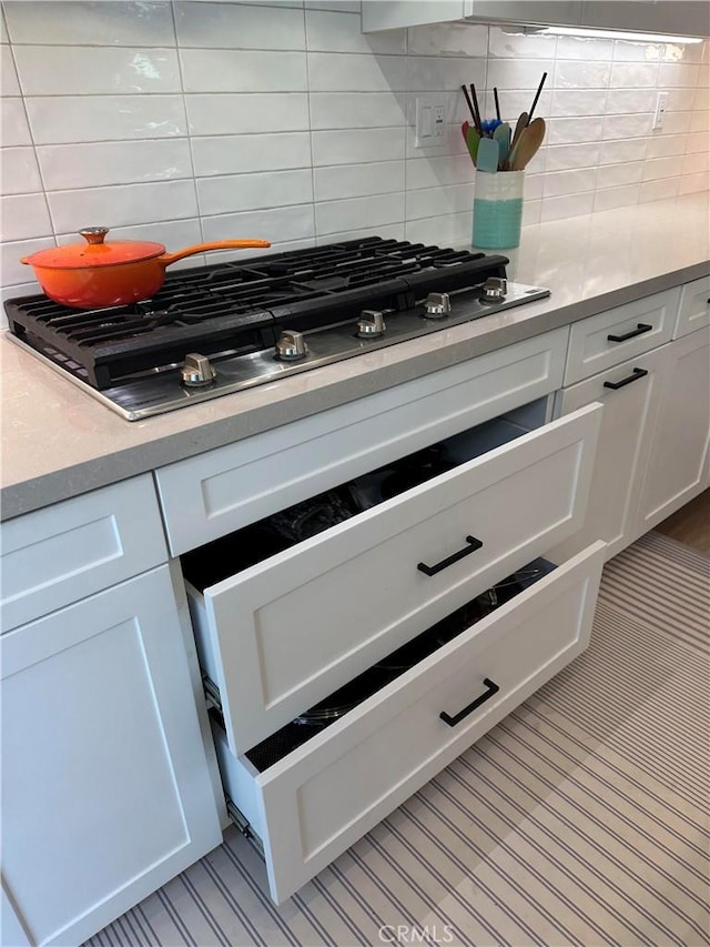 31937 Via Encima, San Juan Capistrano, CA 92675 - kitchen view of stainless steel gas cooktop, backsplash, white cabinetry, and light countertops