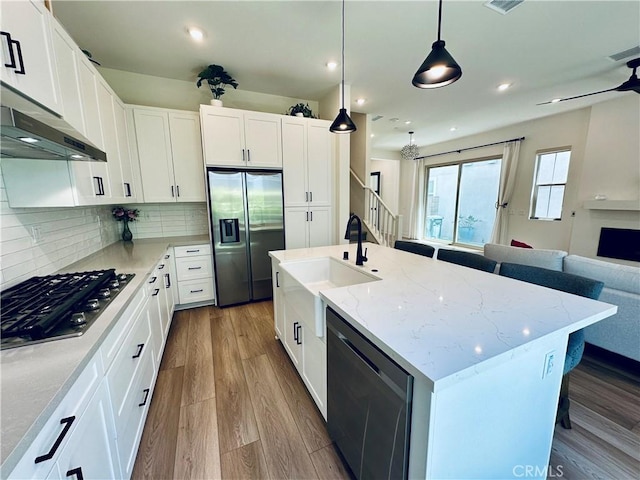 31937 Via Encima, San Juan Capistrano, CA 92675 - kitchen with stainless steel appliances, a sink, open floor plan, wood finished floors, and light stone counters