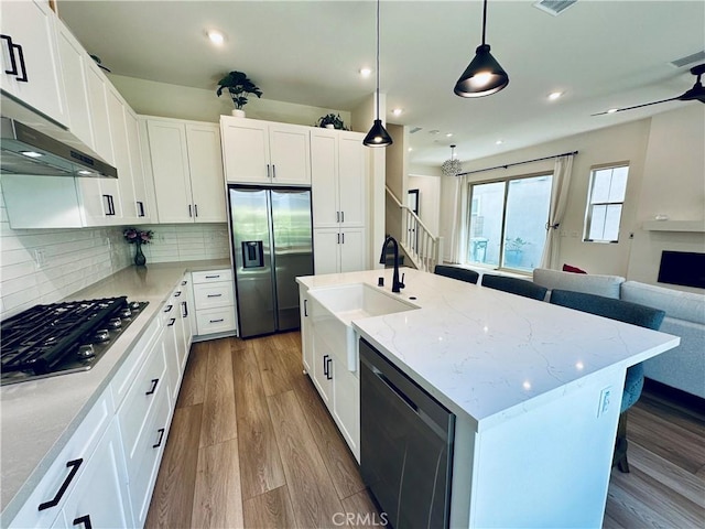 31937 Via Encima, San Juan Capistrano, CA 92675 - kitchen with appliances with stainless steel finishes, open floor plan, wood finished floors, light stone counters, and backsplash
