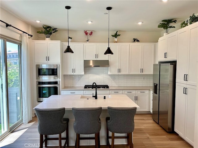 31937 Via Encima, San Juan Capistrano, CA 92675 - kitchen featuring stainless steel appliances, under cabinet range hood, tasteful backsplash, light wood finished floors, and recessed lighting
