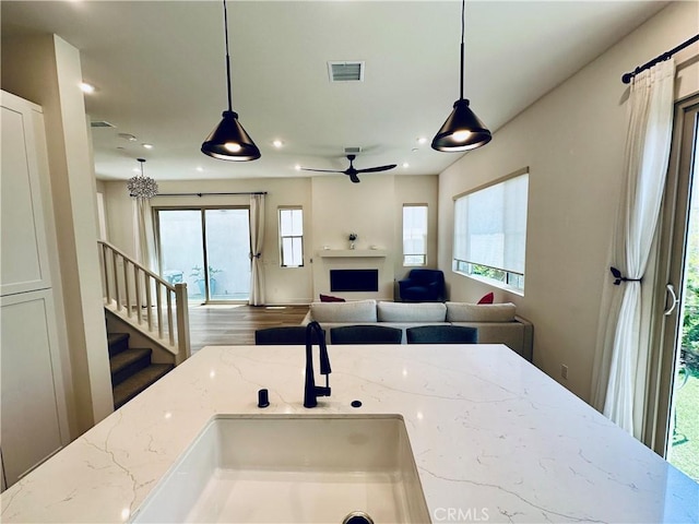31937 Via Encima, San Juan Capistrano, CA 92675 - kitchen featuring light stone counters, plenty of natural light, a fireplace, open floor plan, and recessed lighting