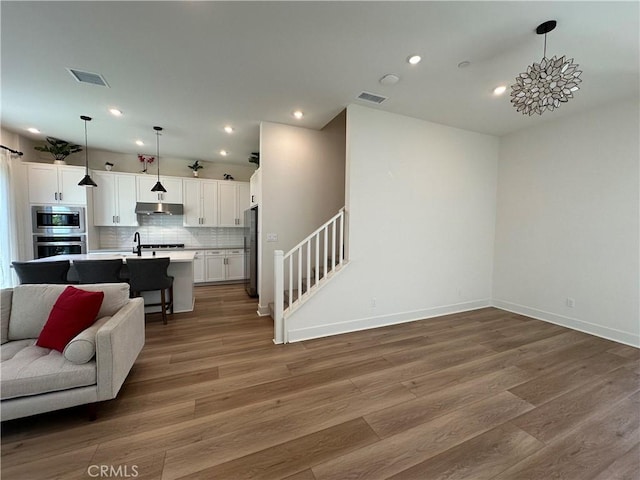 31937 Via Encima, San Juan Capistrano, CA 92675 - living area with light wood-type flooring, baseboards, recessed lighting, and stairs