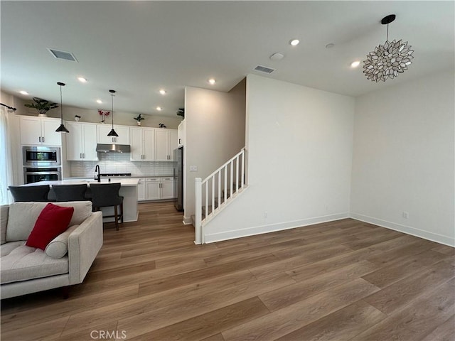 31937 Via Encima, San Juan Capistrano, CA 92675 - living area featuring light wood-style floors, recessed lighting, and stairs