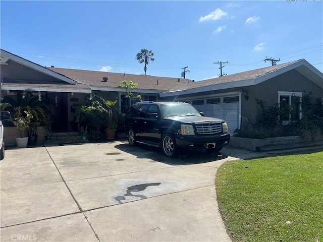 single story home with a front lawn, stucco siding, a garage, and concrete driveway
