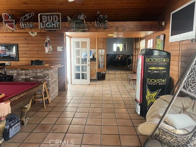 game room featuring wood ceiling, wooden walls, tile patterned flooring, and billiards