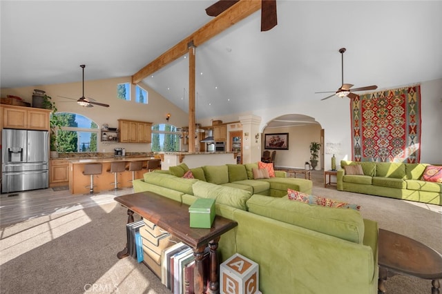 2913 Harris Dr, Vista, CA 92084 - living room with high vaulted ceiling, a ceiling fan, beam ceiling, arched walkways, and light colored carpet