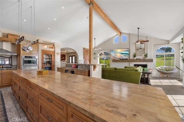 2913 Harris Dr, Vista, CA 92084 - kitchen featuring a ceiling fan, a fireplace, wooden counters, beamed ceiling, and arched walkways