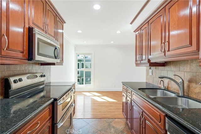 6160 Whitsett Ave Unit 6, North Hollywood, CA 91606 - kitchen featuring stainless steel appliances, crown molding, a sink, baseboards, and dark stone countertops