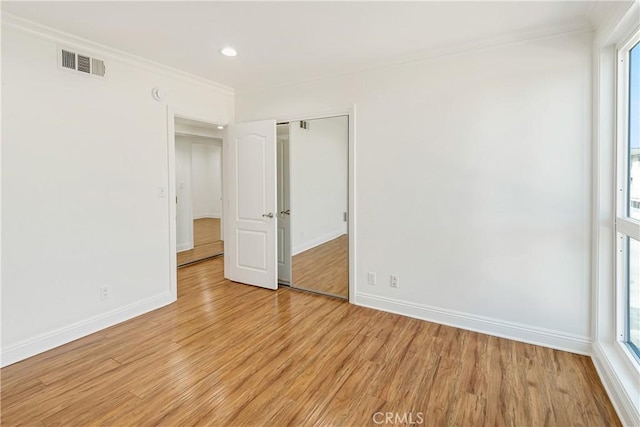 spare room with ornamental molding, visible vents, and light wood finished floors