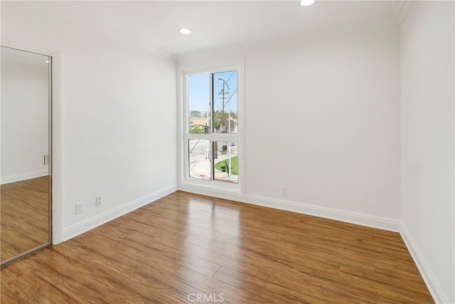 empty room featuring crown molding and wood finished floors
