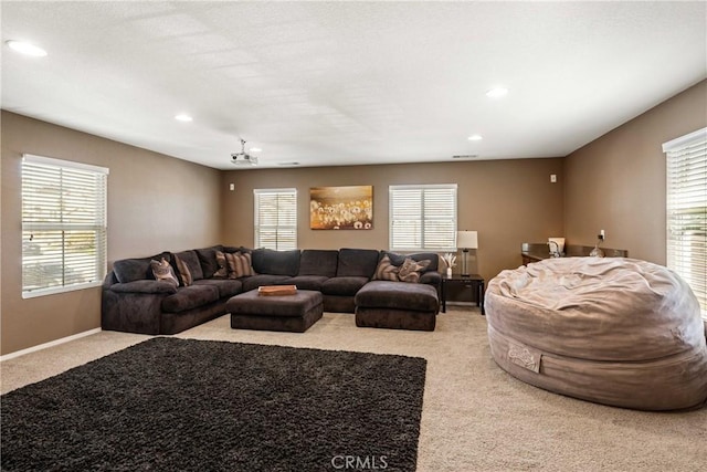 carpeted living room featuring plenty of natural light, recessed lighting, and baseboards