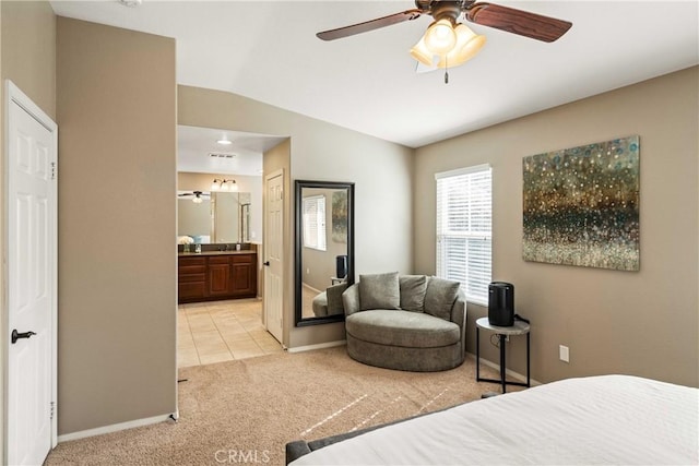 bedroom with light tile patterned floors, light carpet, ensuite bathroom, baseboards, and lofted ceiling