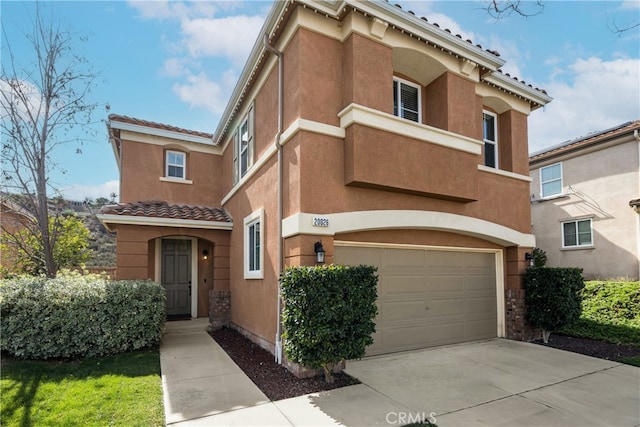 view of front of home featuring stucco siding, driveway, a tile roof, and a garage