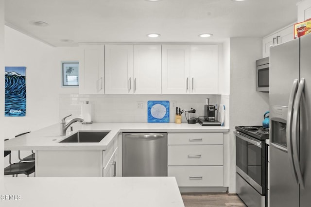 kitchen with decorative backsplash, light countertops, appliances with stainless steel finishes, and a sink