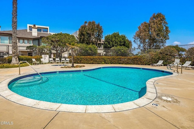pool with a patio and fence